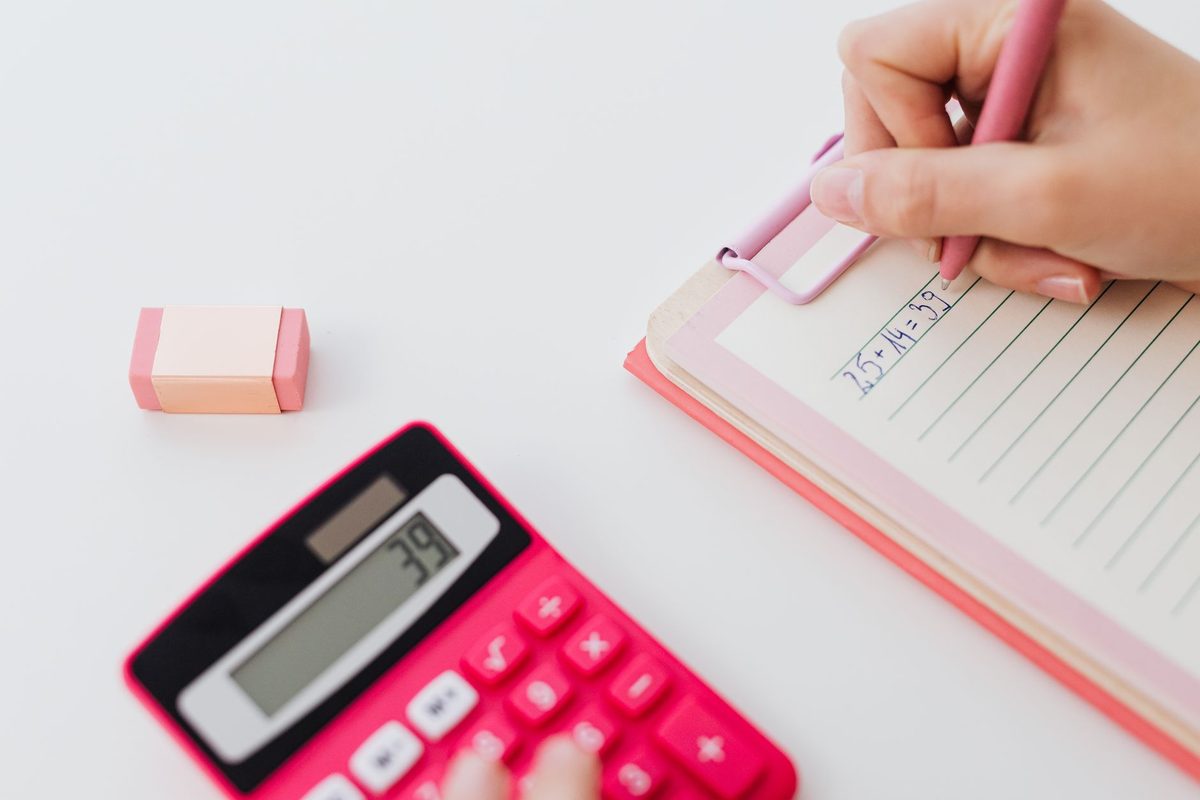 Calculator and clipboard on a desk for working out project costs