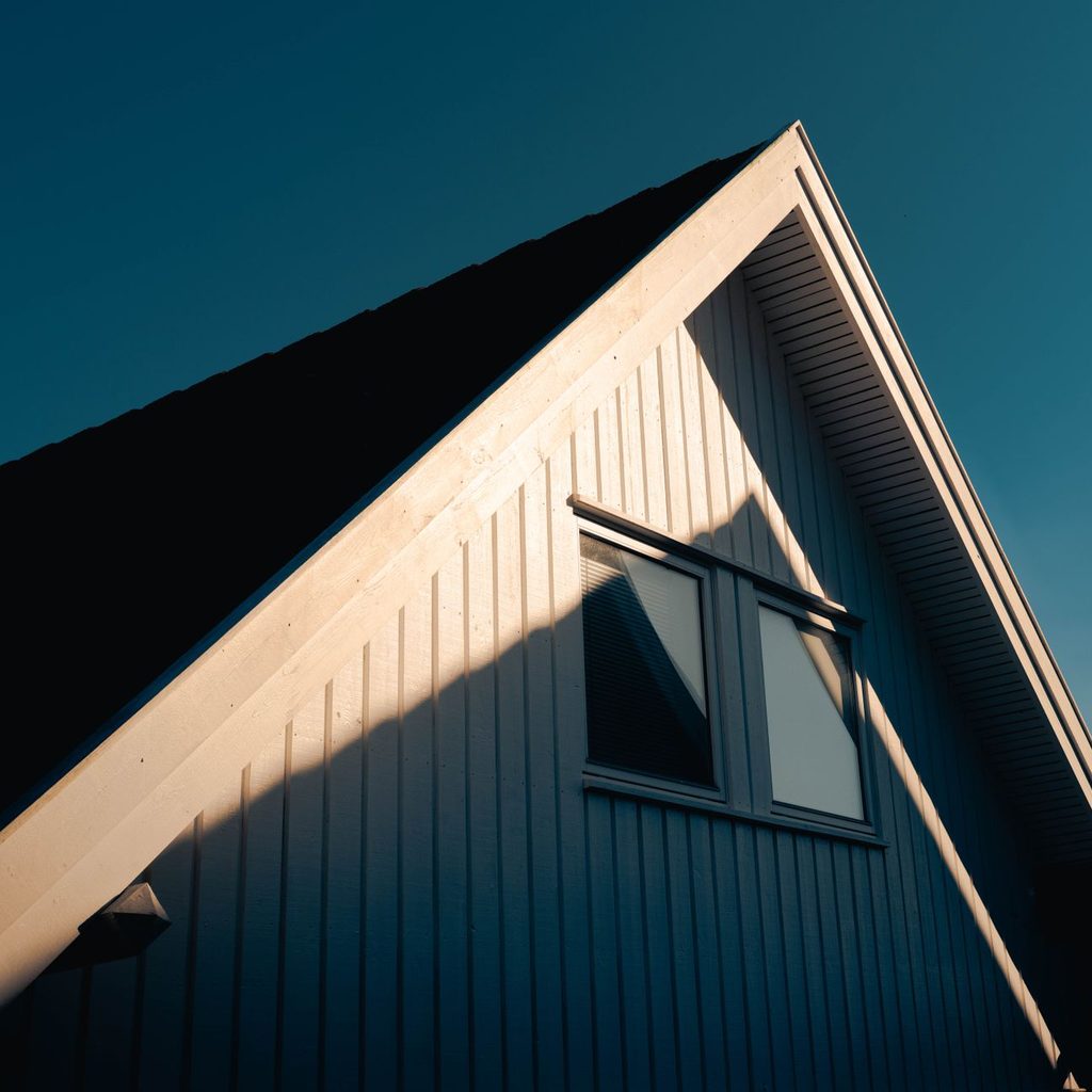 Gable end of a house clad in dark vertical siding